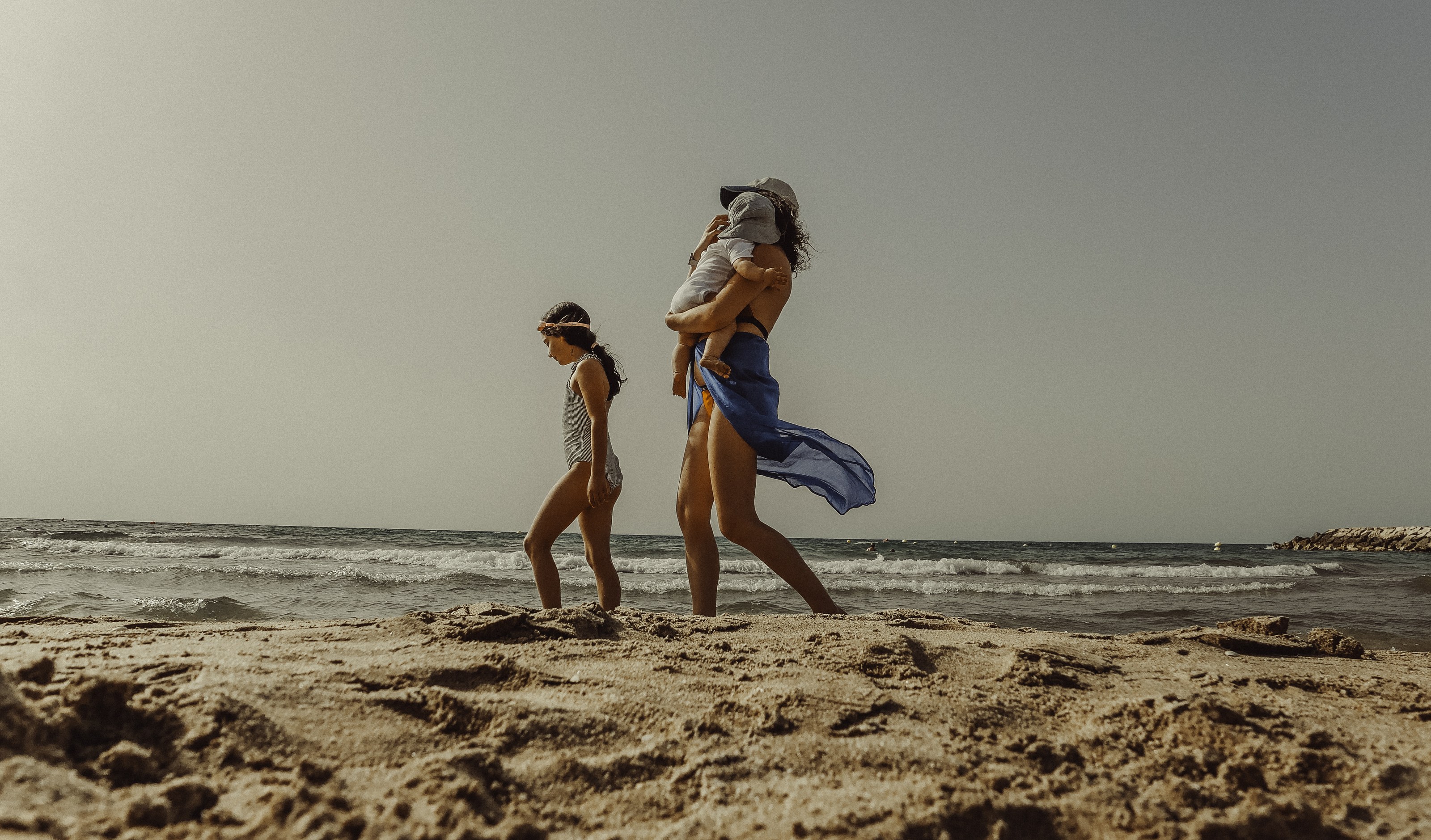 Mother and children crossing the sand